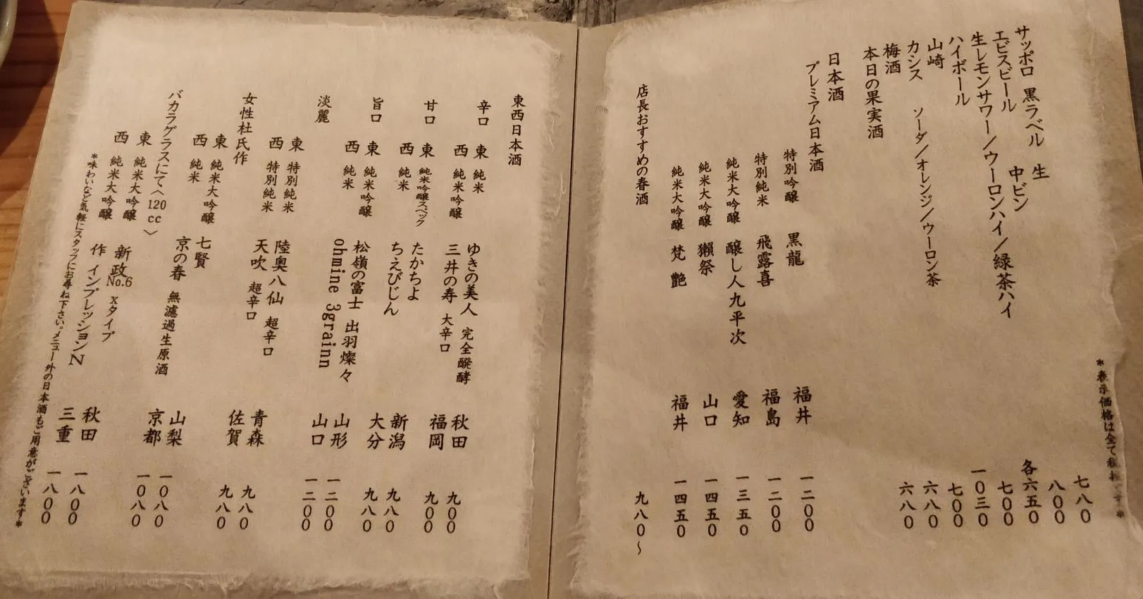 Two-page Japanese sake menu on textured paper with rough deckled edges: beer and premium nihonshu lists on the right, taste-profile sake categories on the left.