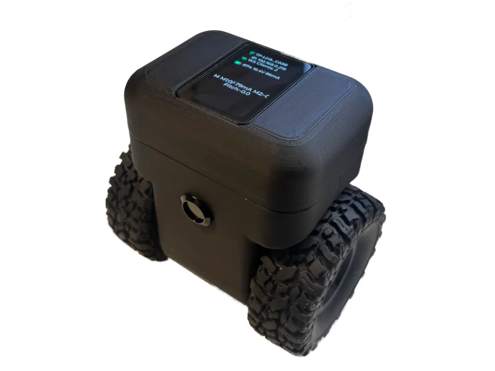 Angled view of the self-balancing robot with top AMOLED showing WiFi, battery, motor current, and pitch telemetry; two knobby RollerCAN wheels and black 3D-printed chassis.